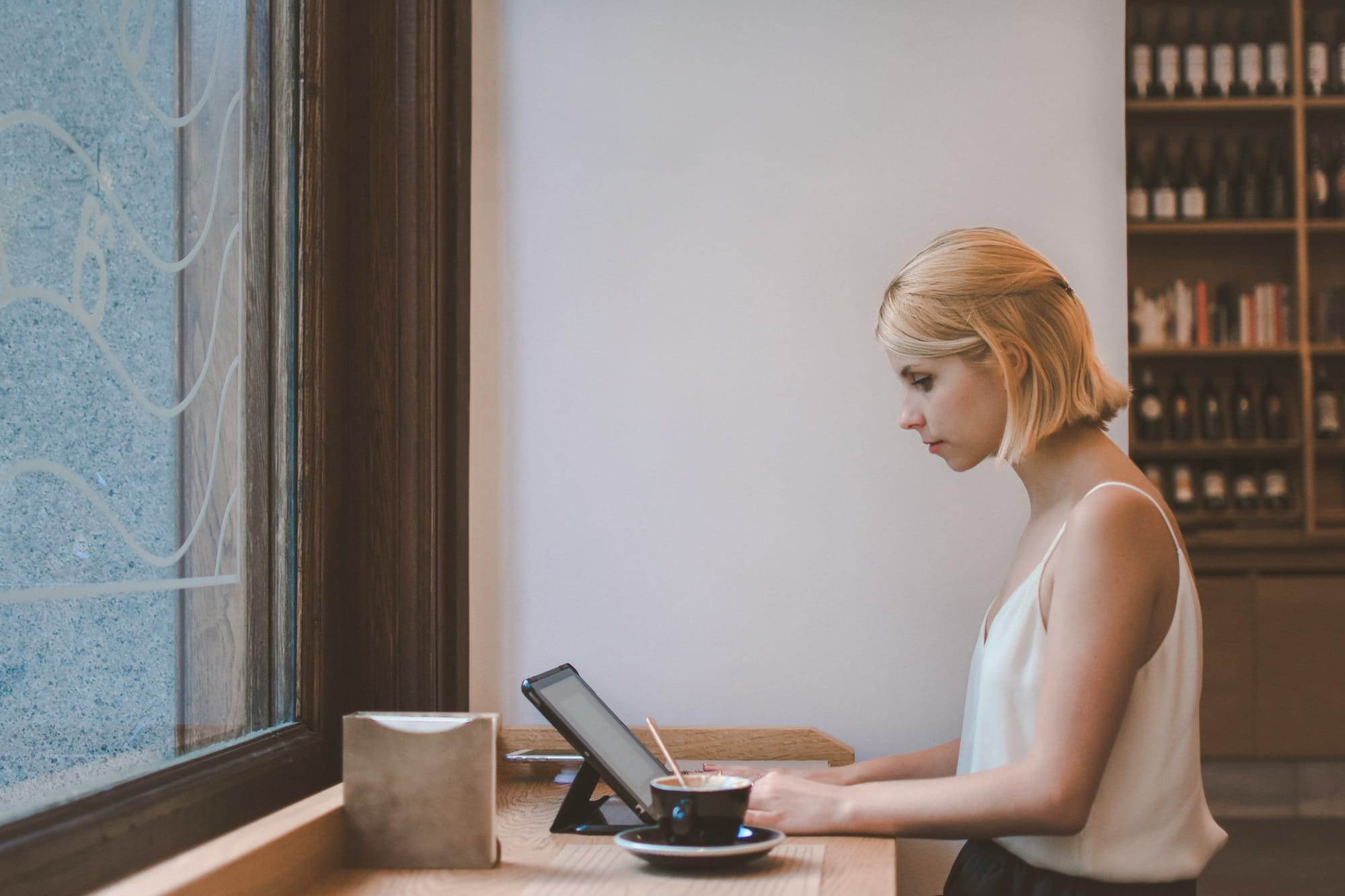 woman infront of a tab - AI Writing News Articles