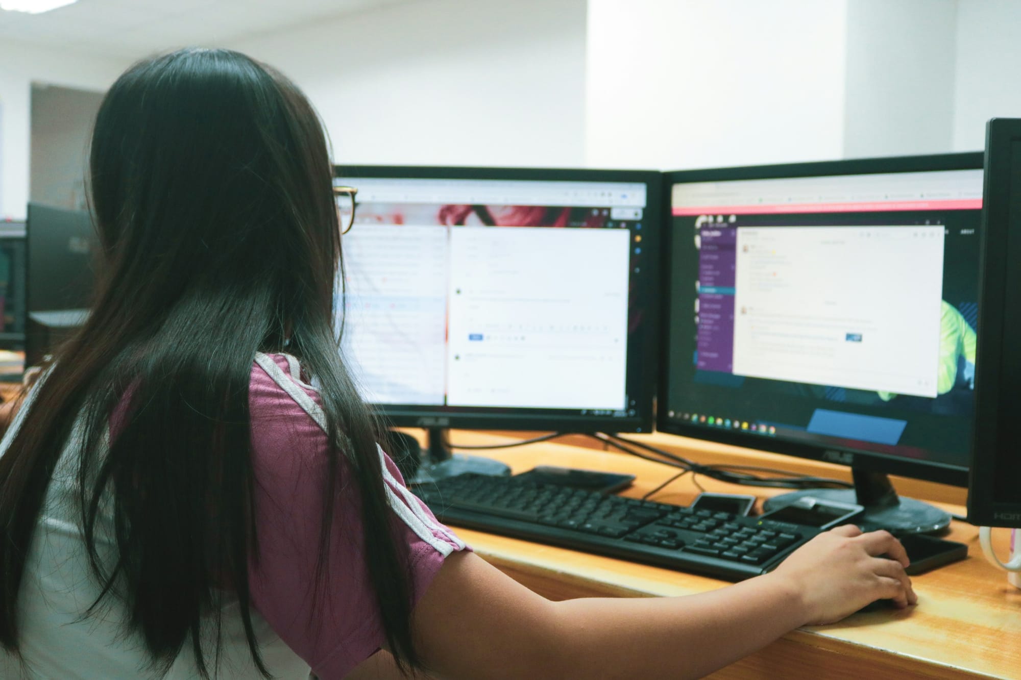 Woman Using Dual Monitor Computer Setup 