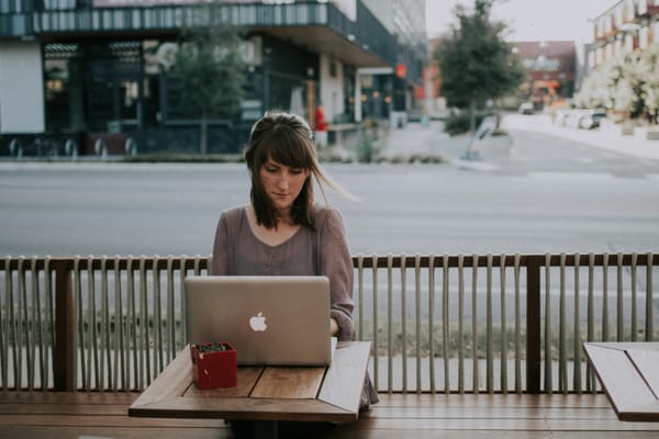 woman sitting outdoor and working - AI Writing Tools